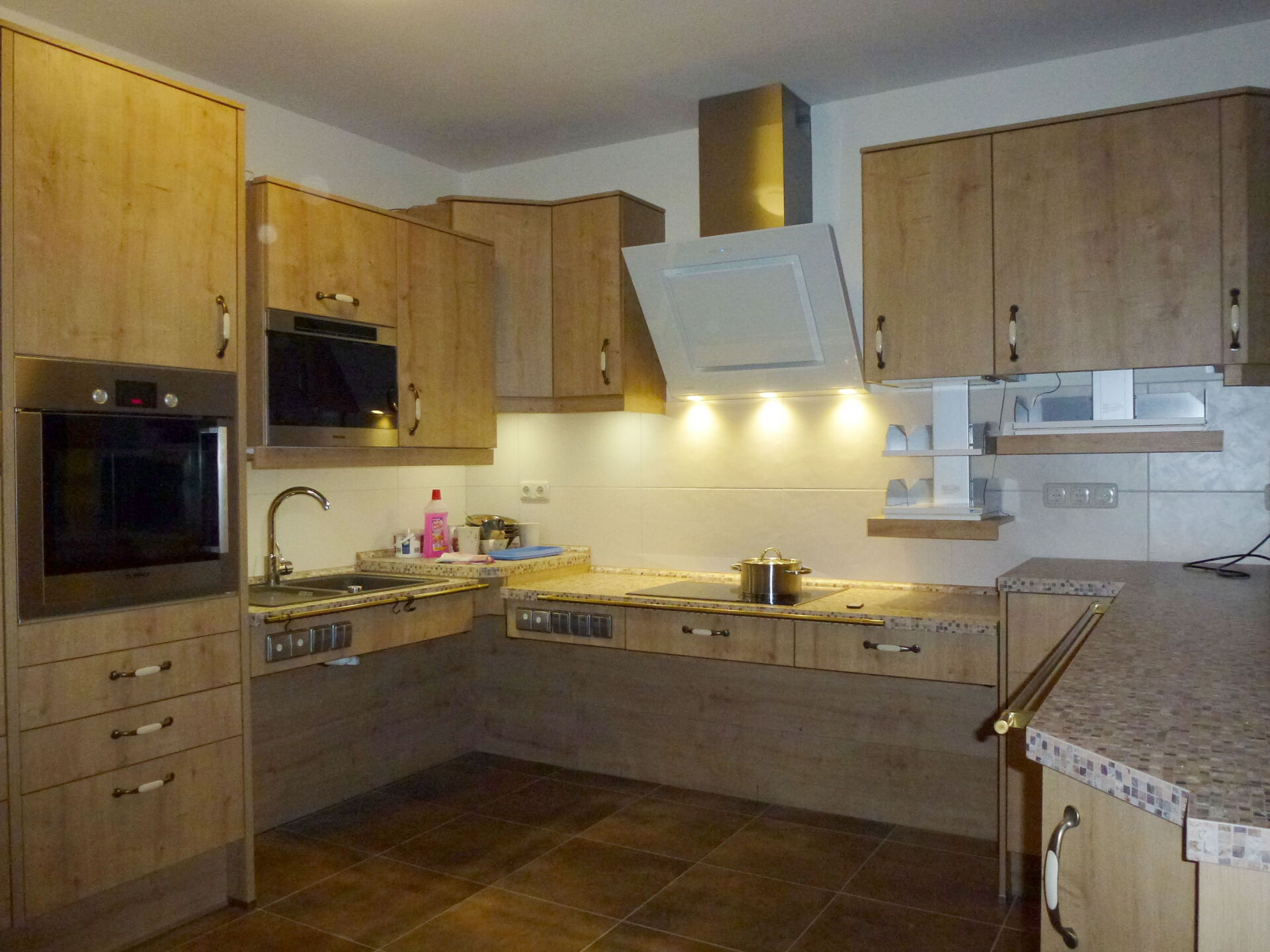 Aufnahme einer Barrierefreien Küche aus Holz mit Backofen, Herdplatte, Mikrowelle und vieles mehr.