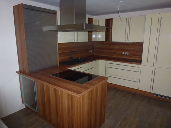 Eine moderne Dachgeschossküche in Beige und Braun mit dunkler Arbeitsplatte. Küchenstudio Mario Pfarsky Hoyerswerda.