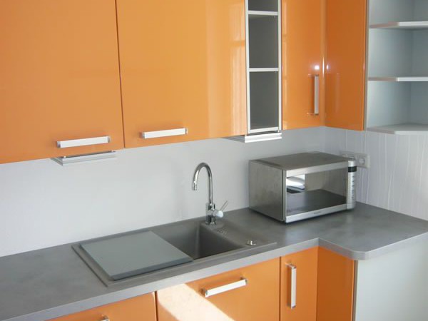 Moderne Sachsenküche in Orange und Grau mit hellen Bodenfliesen. Küchenstudio Mario Pfarsky Hoyerswerda.