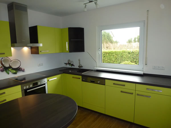 Moderne Sachsenküche Modell Senta in Pistazie mit dunkelgrauer Arbeitsplatte und einem kleinen Esstisch. Küchenstudio Pfarsky Hoyerswerda.